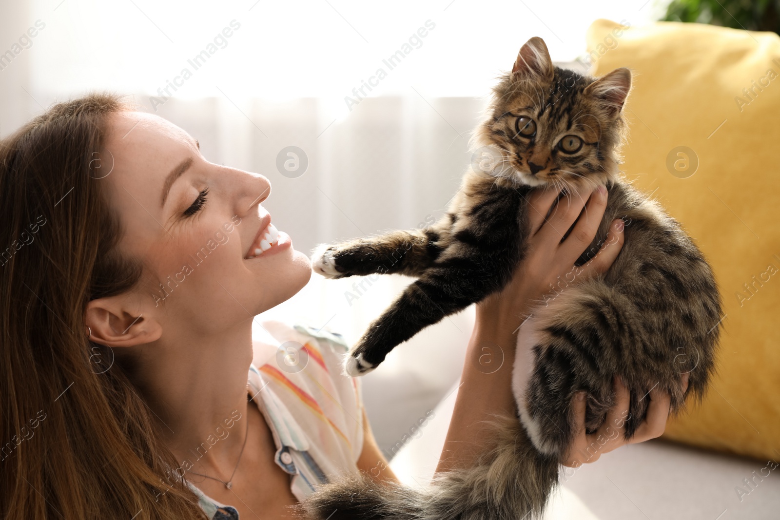 Photo of Woman with cat in living room. Owner and pet