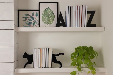 Photo of Bookends and other decor on shelves indoors. Interior design