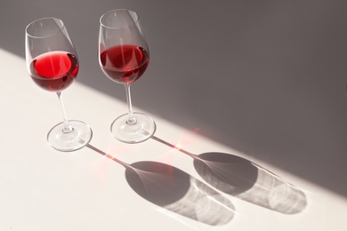 Photo of Glasses with delicious wine on table indoors