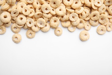 Tasty cereal rings on white background, flat lay. Space for text