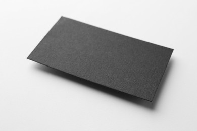 Photo of Blank black business card on white background, closeup. Mockup for design