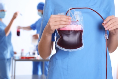 Doctor holding blood pack for transfusion at hospital, closeup. Donation day