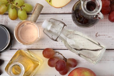 Photo of Different types of vinegar and ingredients on wooden table, flat lay