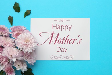 Image of Happy Mother's Day greeting card and beautiful chrysanthemum flowers on light blue background, flat lay
