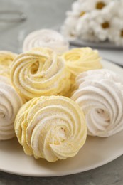 Delicious white and yellow marshmallows on grey table, closeup