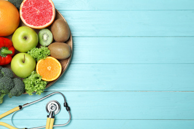 Photo of Fruits, vegetables and stethoscope on light blue wooden background, flat lay with space for text. Visiting nutritionist