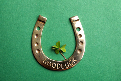 Photo of Flat lay composition with horseshoe on green background. St. Patrick's Day celebration