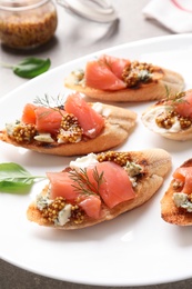 Photo of Tasty bruschettas with salmon and blue cheese served on table