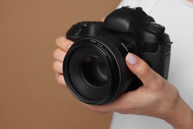 Photo of Photographer with camera on brown background, closeup