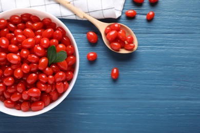 Fresh ripe goji berries on blue wooden table, flat lay. Space for text