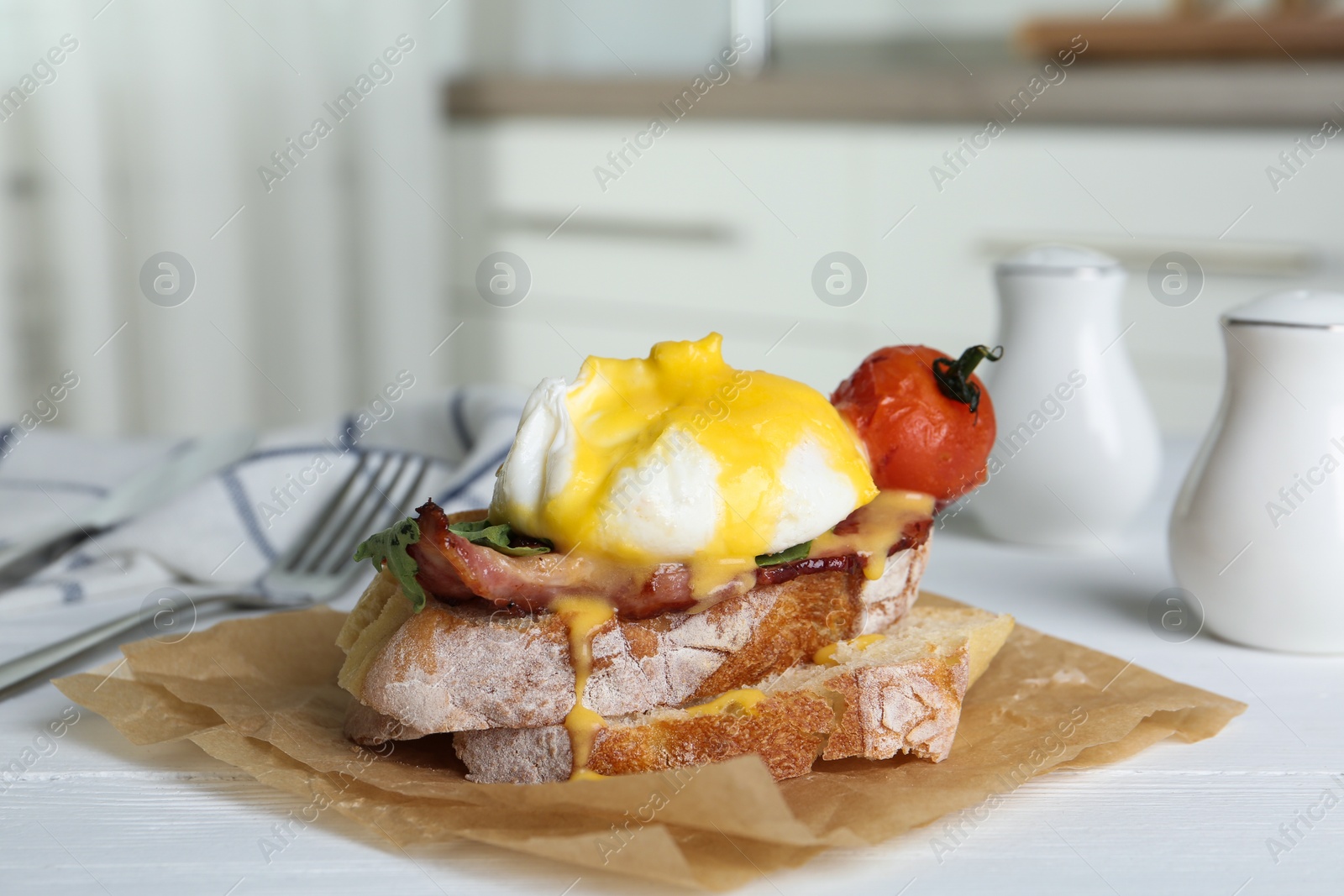 Photo of Delicious egg Benedict served on white wooden table