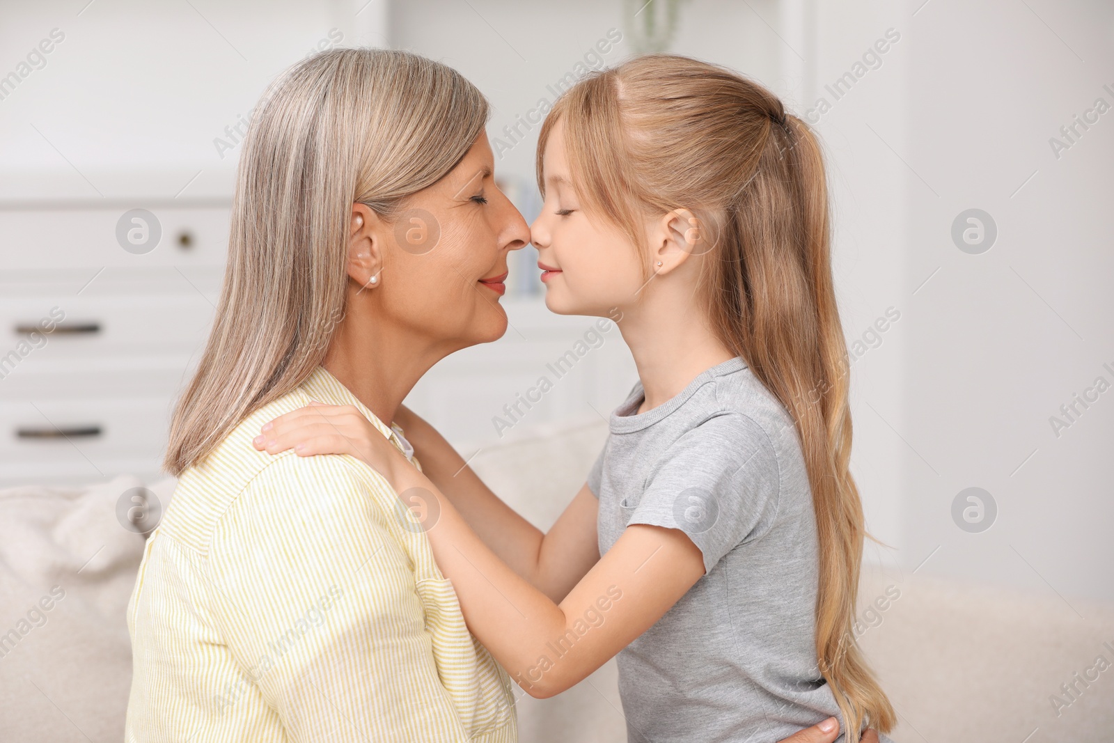Photo of Happy grandmother with her granddaughter at home
