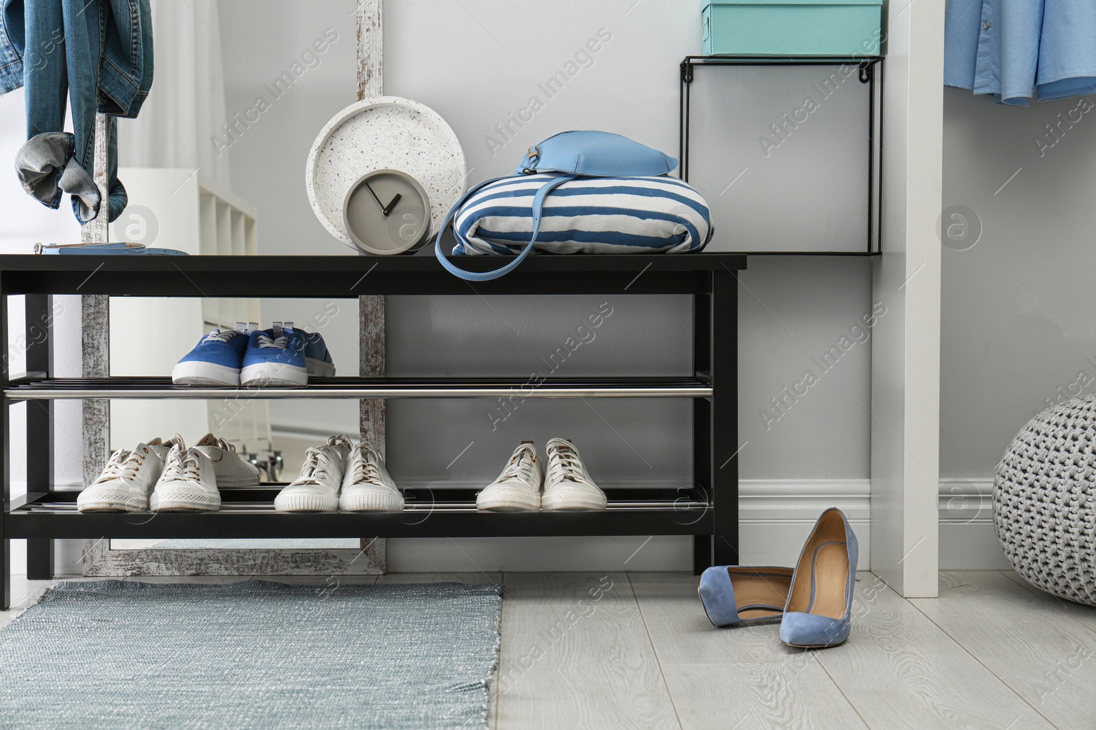 Stylish hallway interior with shoe rack and rug Photo of Stylish hallway interior with shoe rack and rug
