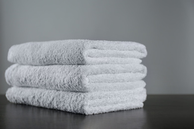 Photo of Stack of clean bath towels on dark grey table