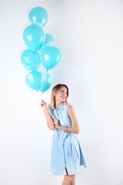 Young woman with air balloons on white background