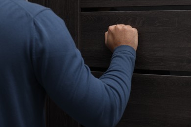 Photo of Collection agent knocking on wooden door, closeup