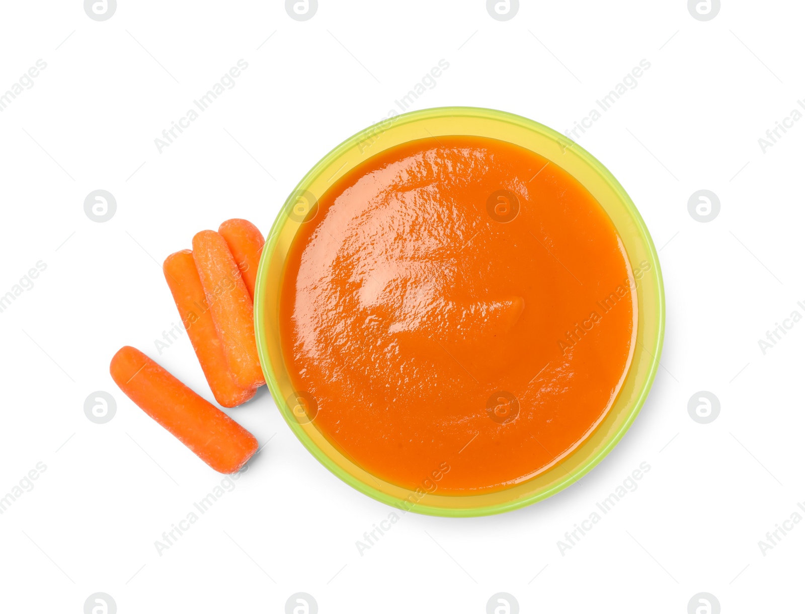 Photo of Delicious baby food in bowl and fresh carrots isolated on white, top view