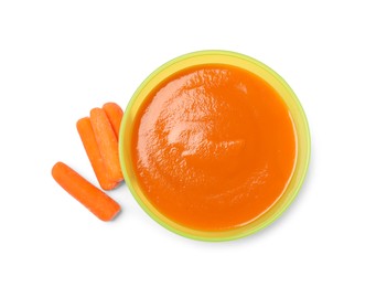 Delicious baby food in bowl and fresh carrots isolated on white, top view