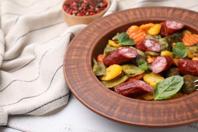 Photo of Delicious sausage and baked vegetables on table, closeup