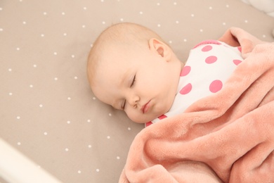 Cute baby girl sleeping in crib. Bedtime schedule