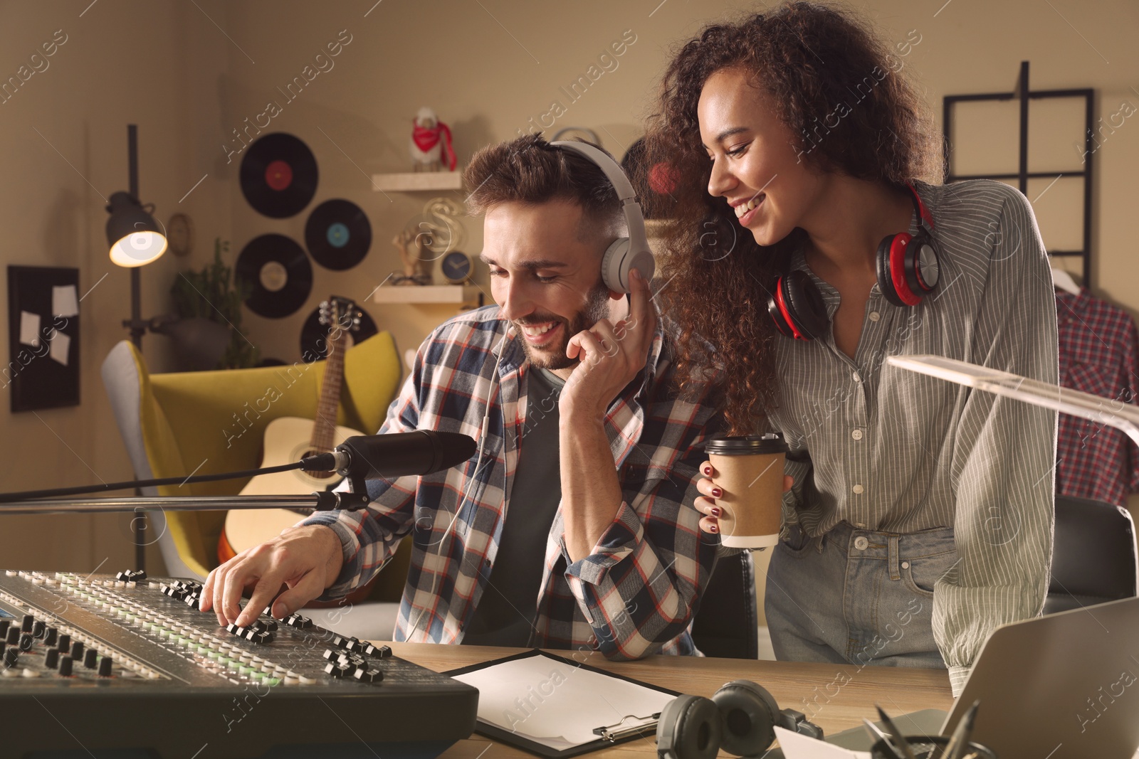 Photo of People working in modern radio studio with professional equipment
