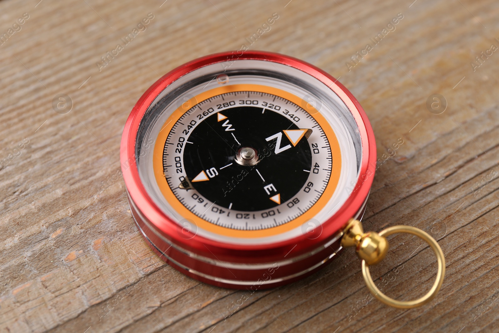 Photo of One compass on wooden table. Navigation equipment