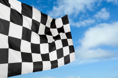 Image of Checkered racing finish flag against blue sky