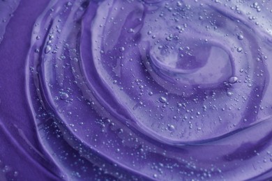 Photo of Transparent shower gel on violet background, closeup