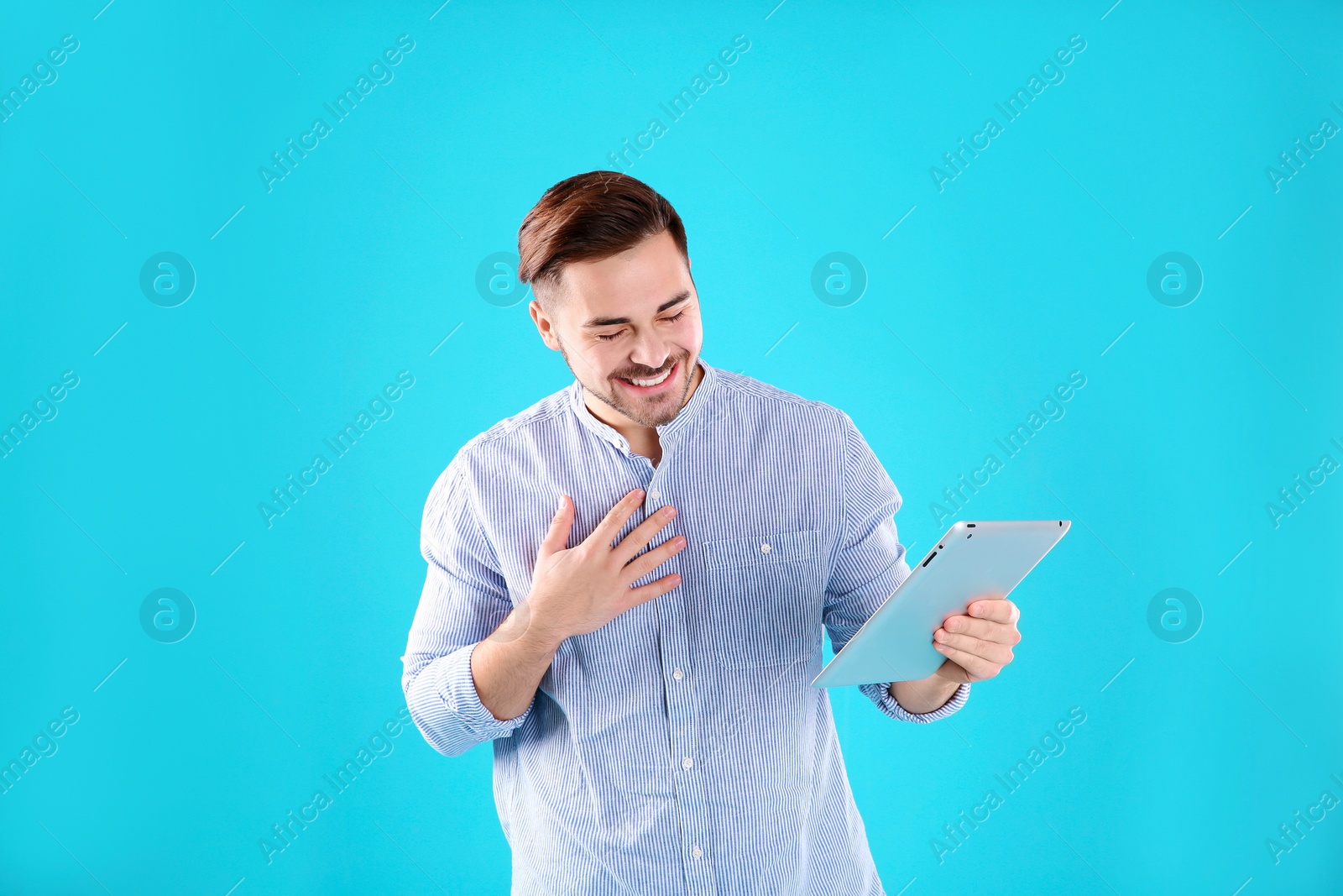 Photo of Man using tablet for video chat on color background