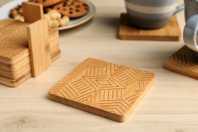 Photo of Many stylish wooden cup coasters on table
