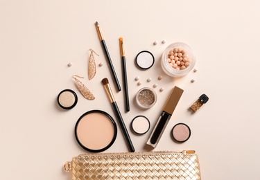 Photo of Cosmetic bag and different luxury makeup products on color background, flat lay