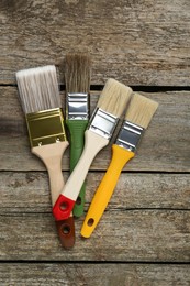 Different brushes on wooden table, flat lay