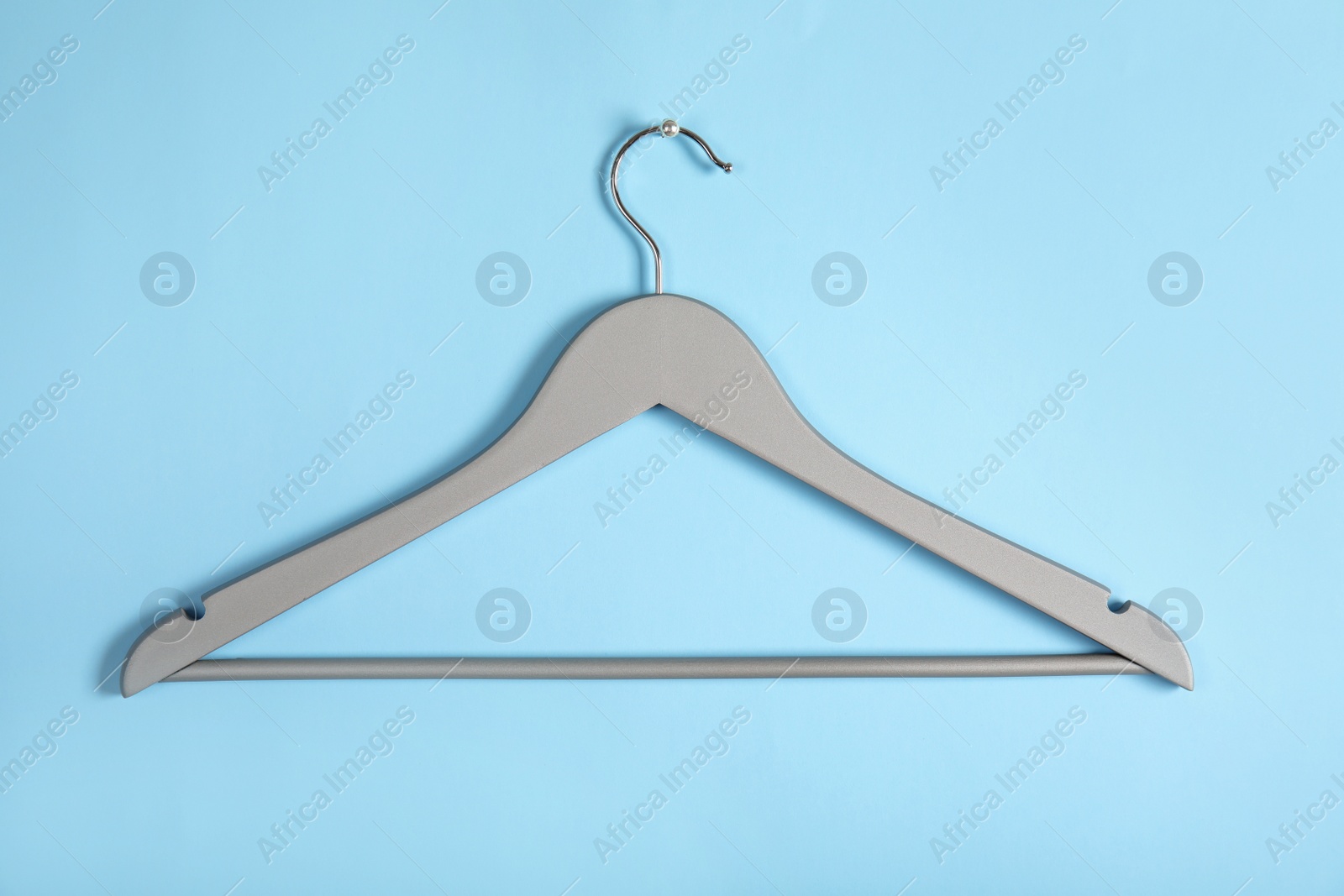 Photo of Empty clothes hanger on color background. Wardrobe accessory