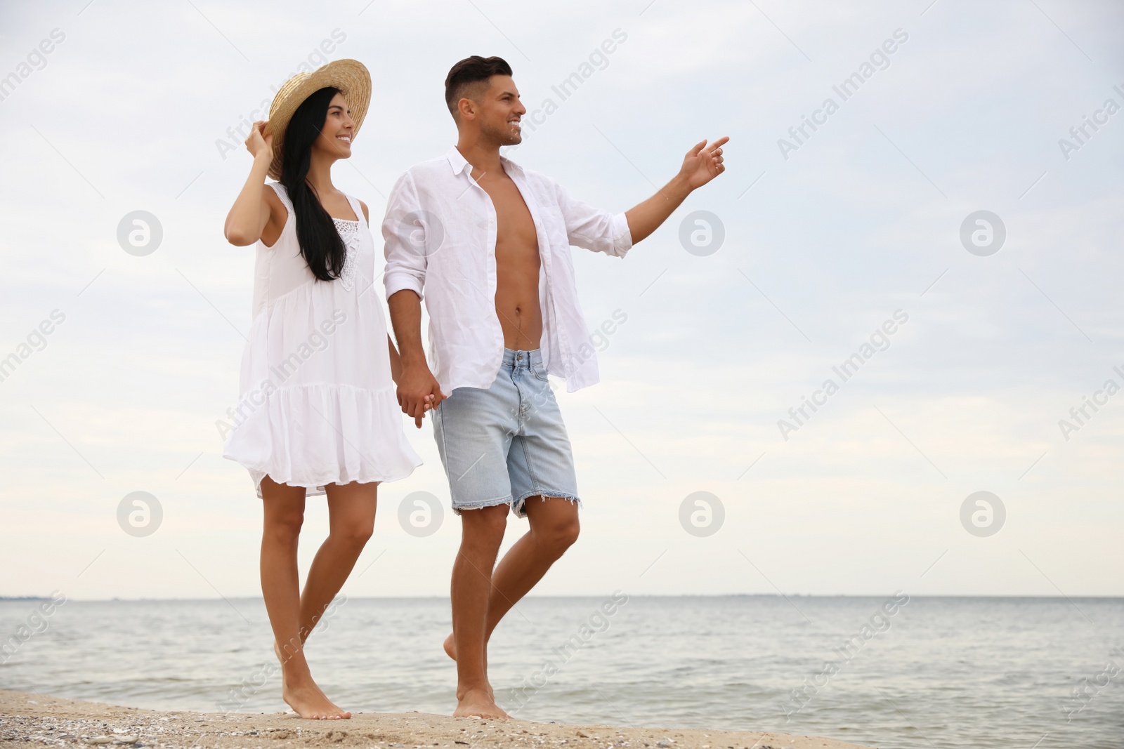 Photo of Lovely couple walking on beach. Space for text