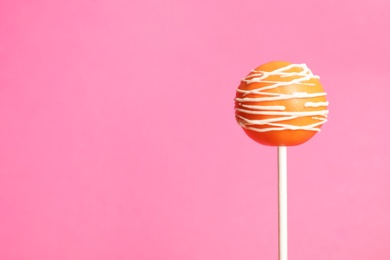 Photo of Bright delicious cake pop on color background. Space for text