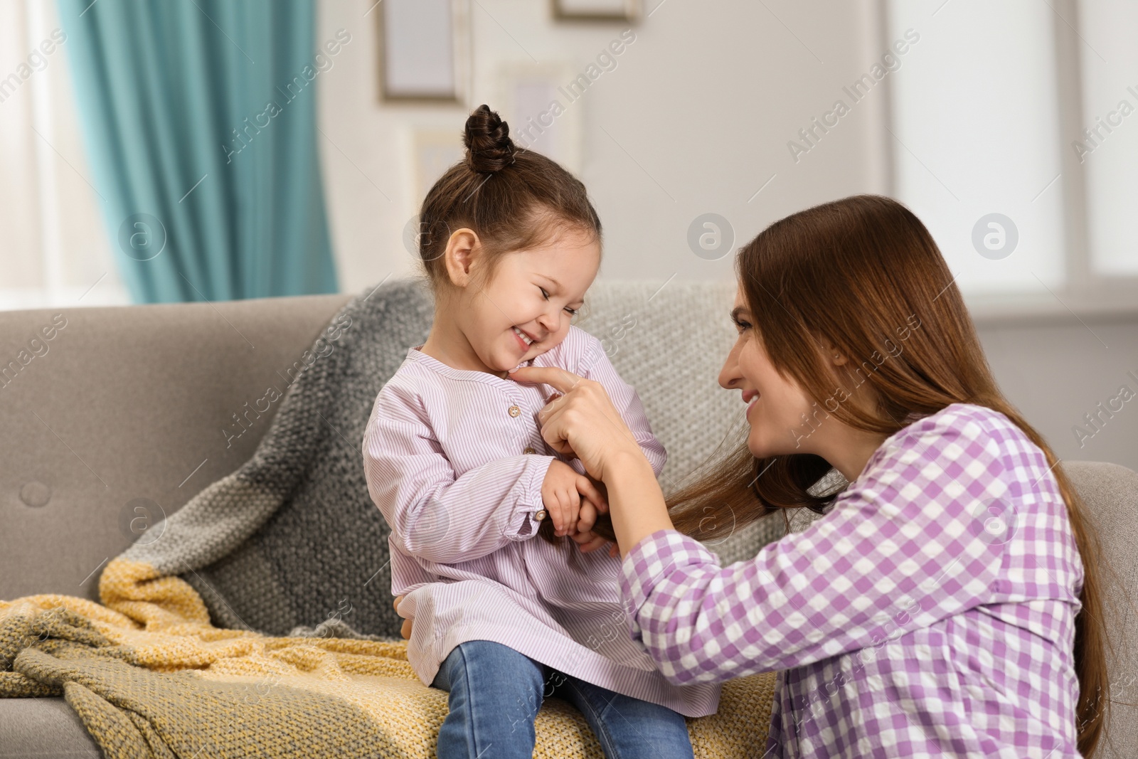 Photo of Young mother with little daughter at home