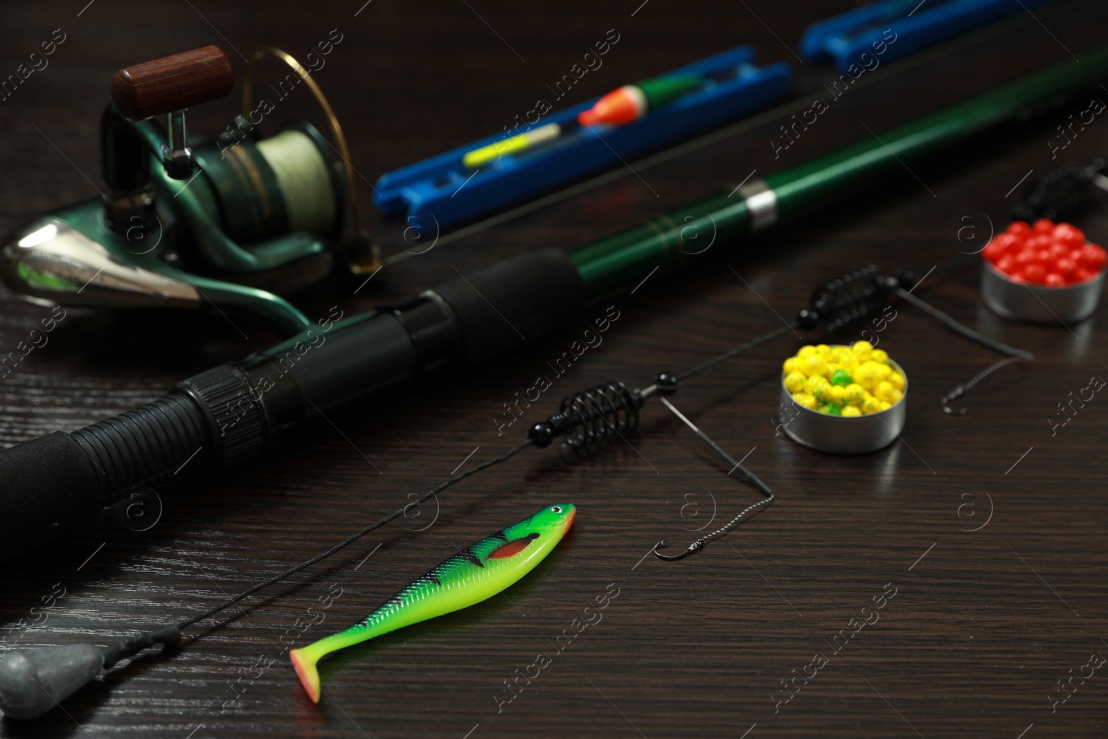 Photo of Fishing tackle on dark wooden background, closeup