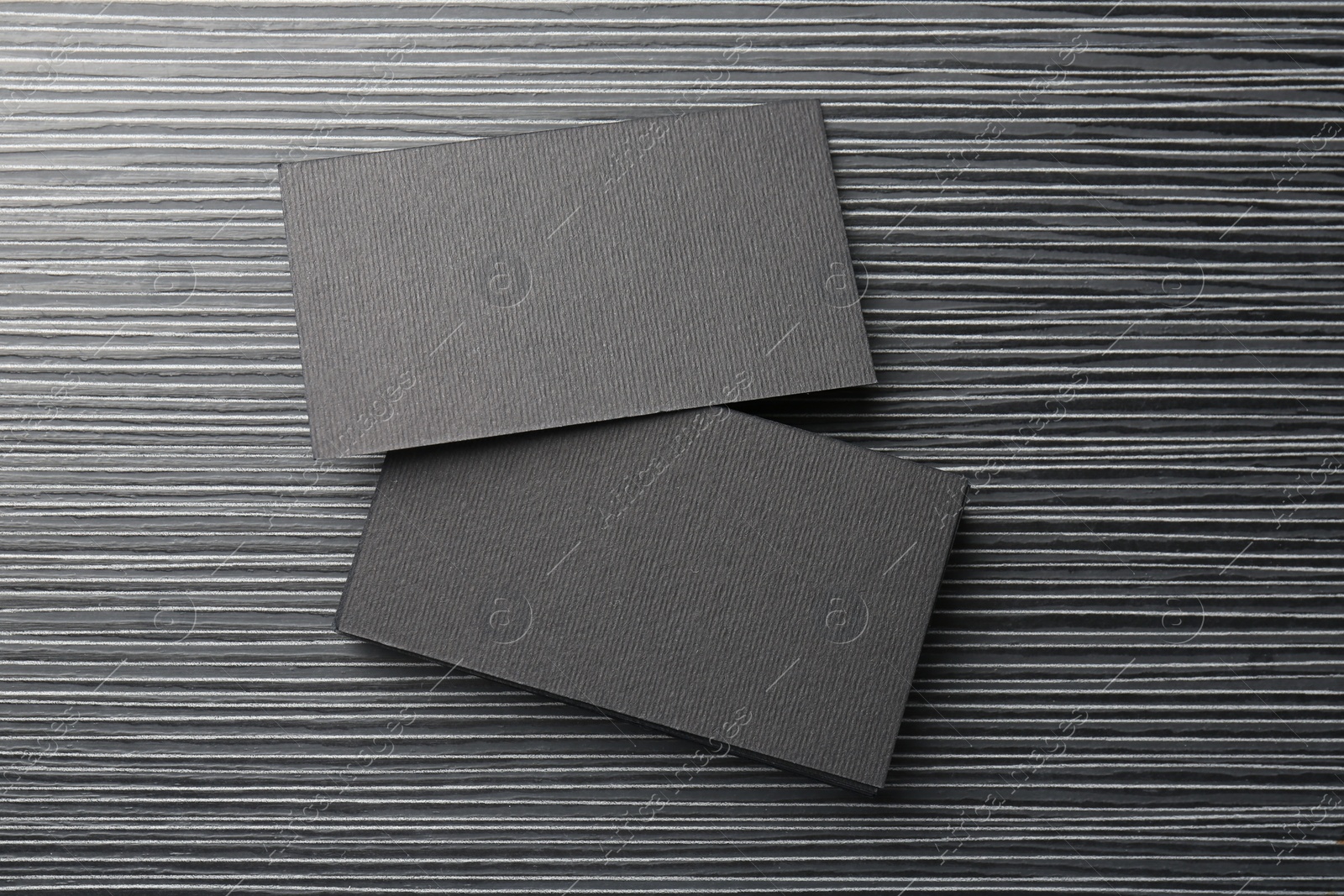 Photo of Blank black business cards on wooden table, top view. Mockup for design