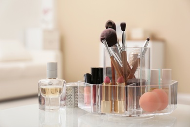 Photo of Organizer with cosmetic products for makeup on table indoors