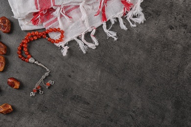 Photo of Flat lay composition with Muslim prayer beads, dates and space for text on grey background