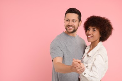 Photo of International dating. Happy couple dancing on pink background. Space for text