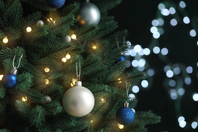 Photo of Beautiful Christmas tree with decor against blurred lights on background