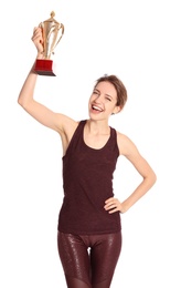 Portrait of happy young sportswoman with gold trophy cup on white background