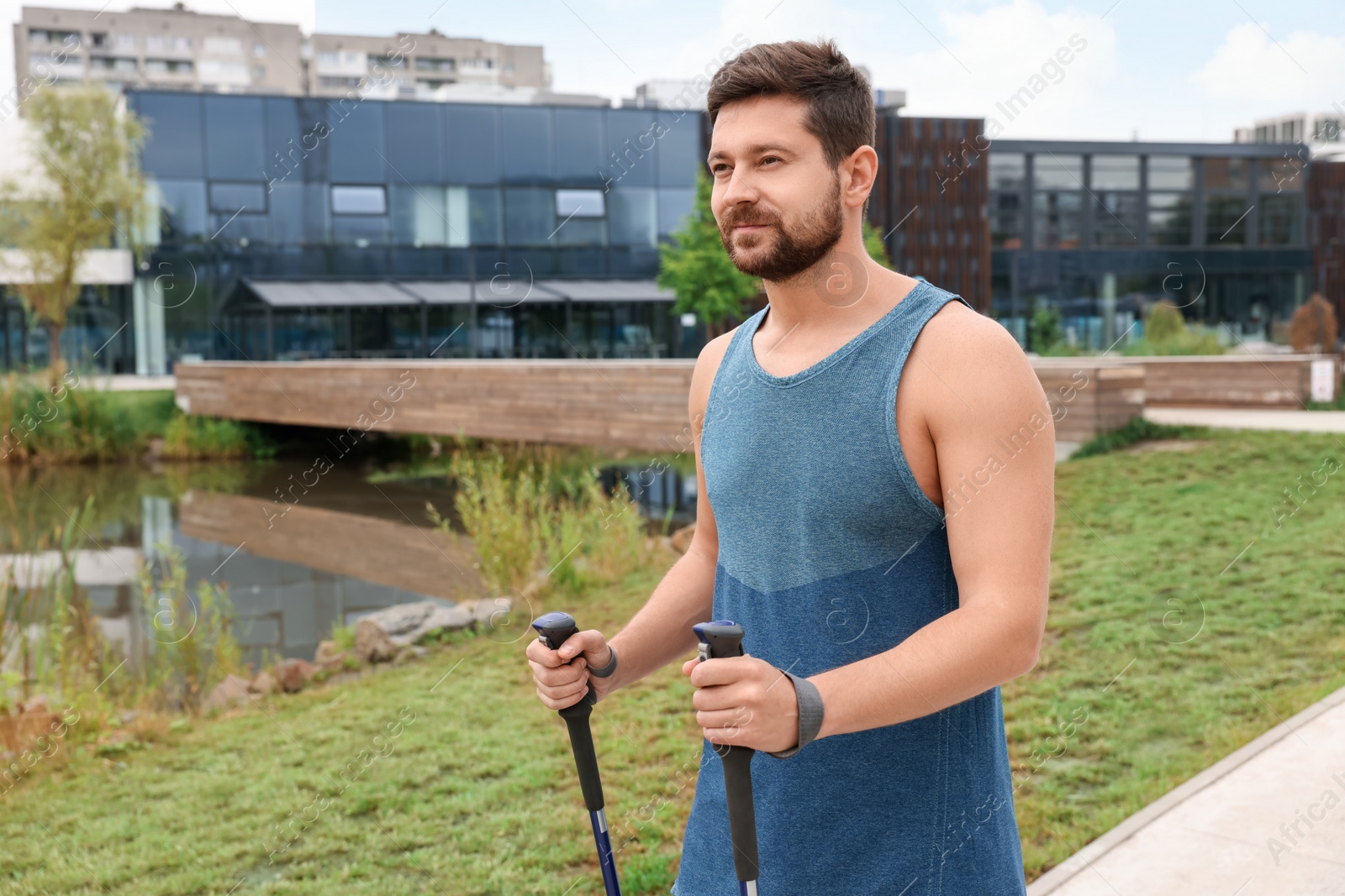 Photo of Man practicing Nordic walking with poles outdoors. Space for text