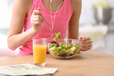 Photo of Young woman in fitness clothes having healthy breakfast at home, closeup