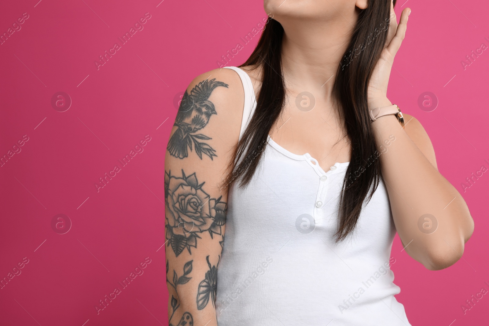 Photo of Woman with tattoos on arm against pink background, closeup. Space for text