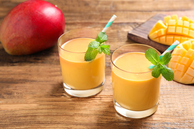 Fresh delicious mango drink on wooden table