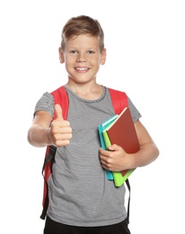 Photo of Cute boy with school stationery showing thumb up on white background