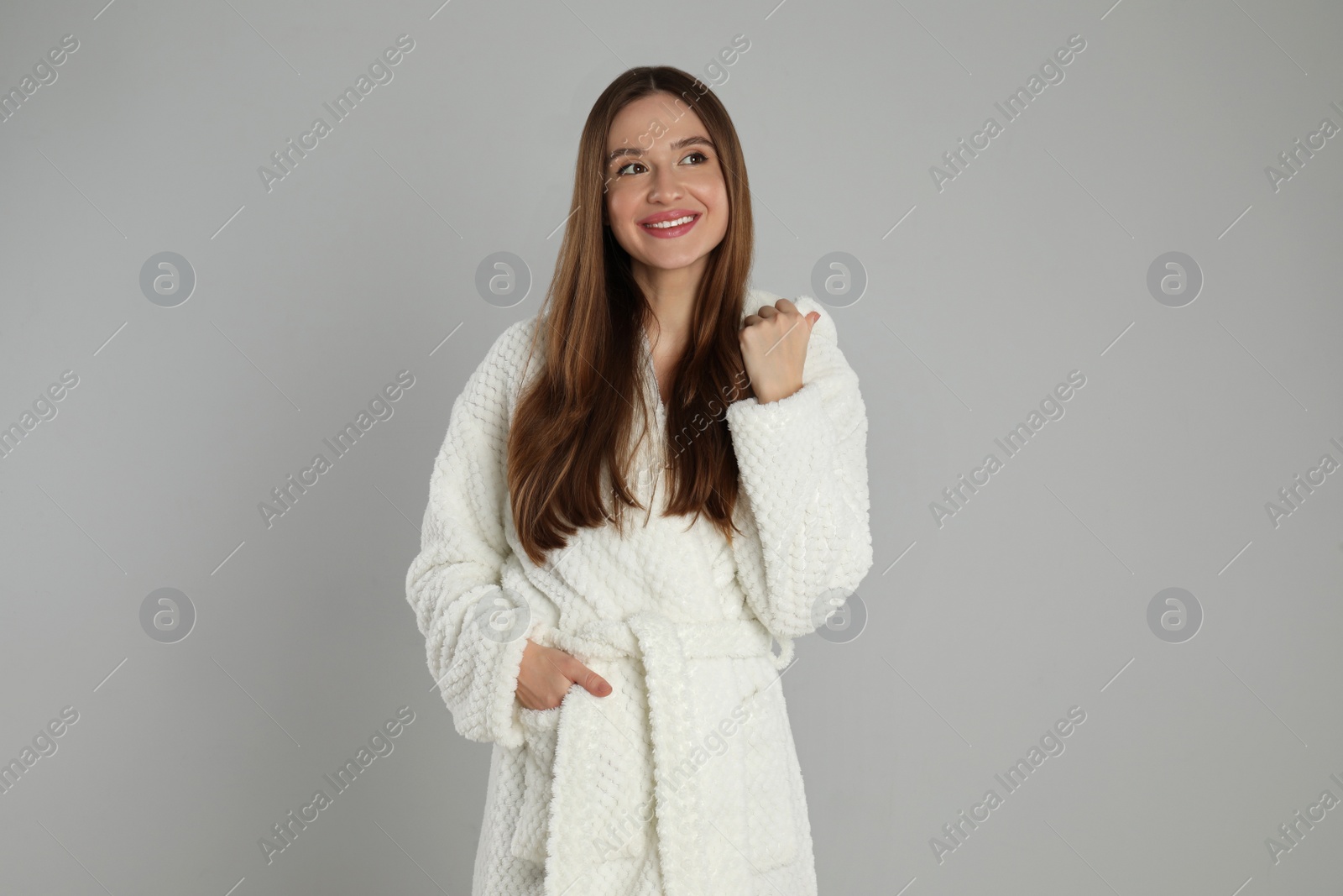 Photo of Beautiful young woman in bathrobe on light grey background