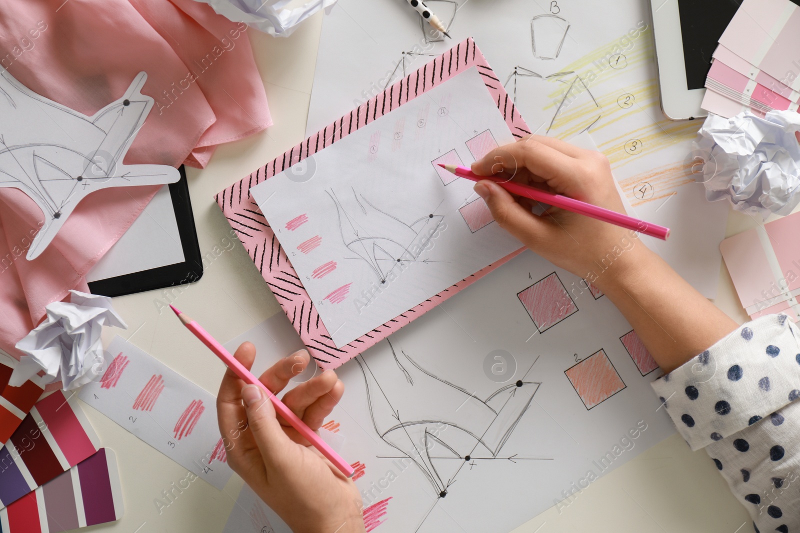 Photo of Female fashion designer working at white table, top view